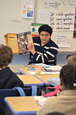 Pablo Tutillo '13 reads to fourth graders at New London’s Winthrop Magnet Elementary School.