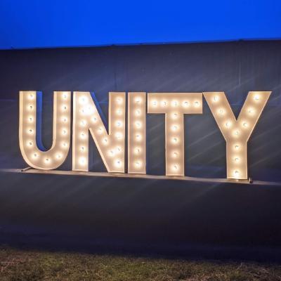 Lit up Unity sign from Unity House 50th Celebration