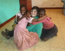 Gabby Arenge '14 poses with children in Kibera.