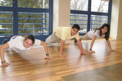 Jessie Mehrhoff '14 shows two middle school students the correct way to do push-ups.