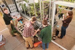 Chad Jones, the Milne Assistant Professor of Botany and Environmental Sciences at Connecticut College, left, helps first-year botany students prepare to plant seedlings in the renovated greenhouse.