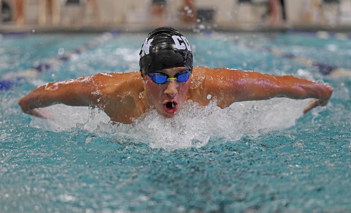 Justin Finkel races through the water at a swim meet.