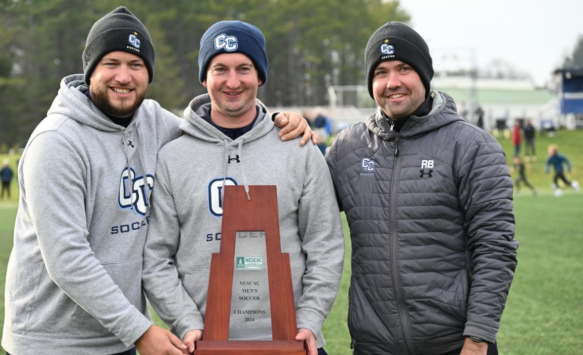 Coaches of the Men's Soccer Team Pose with Trophy.