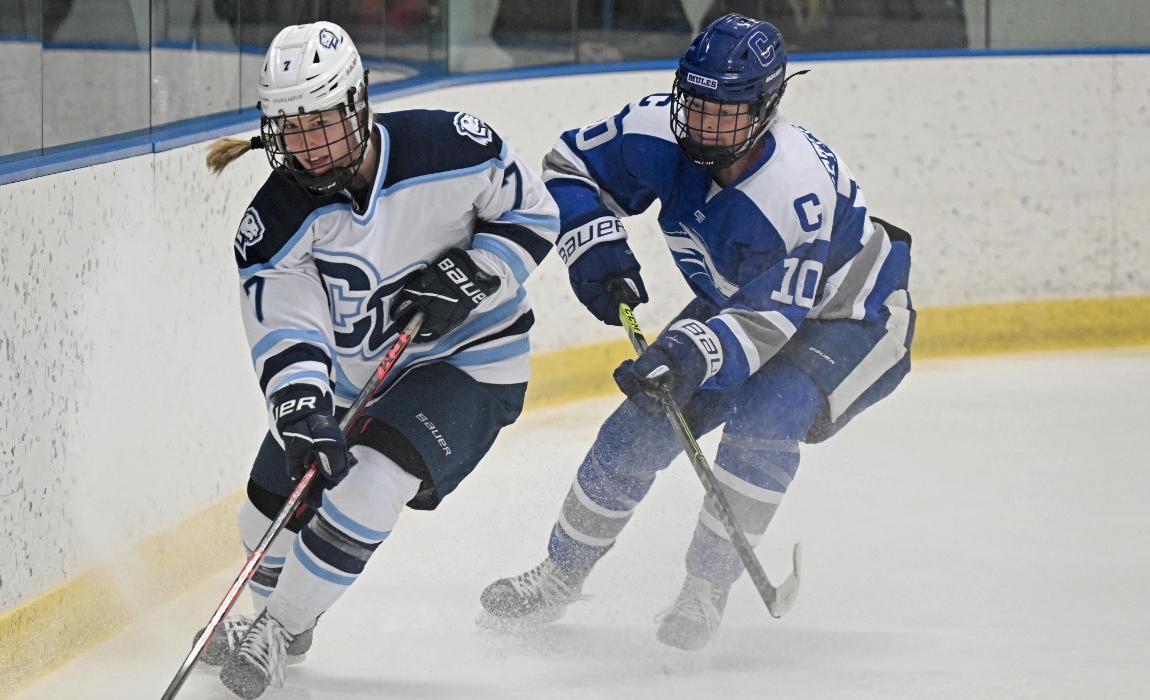 Women's Hockey defender racing for the puck.