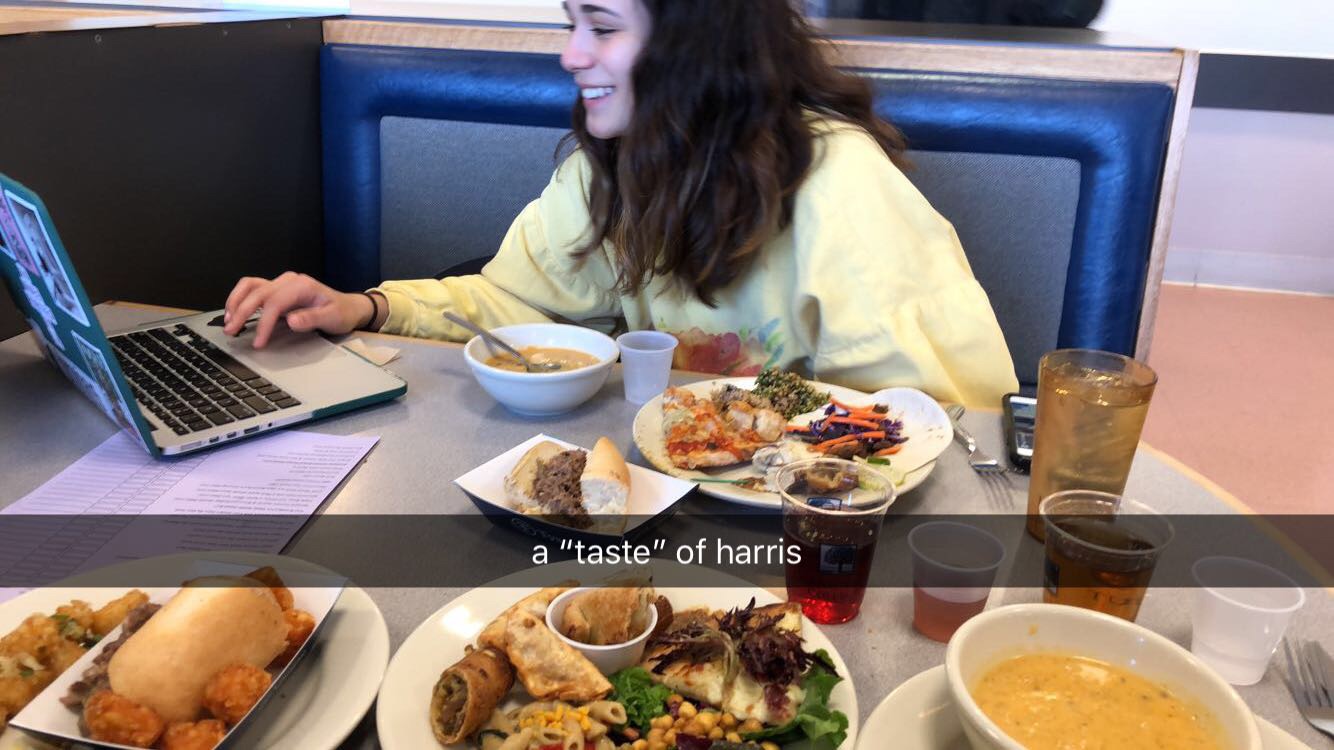 Dani Maney ’21 sits at a booth in Harris with her laptop out and a number of plates piled with food from A Taste of Harris