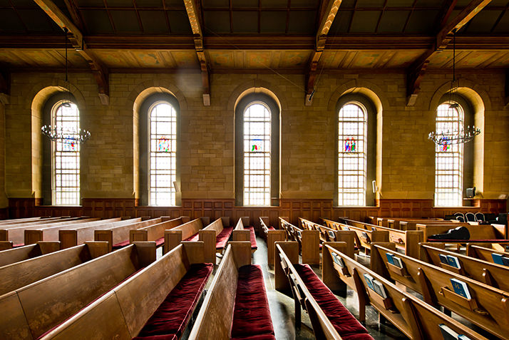 Harkness Chapel interior showing chestnut pews and stained glass windows