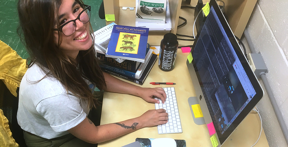 Ariane Buckenmeyer '19 smiles at her desk 