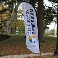 A photo of the All College Symposium banner on campus