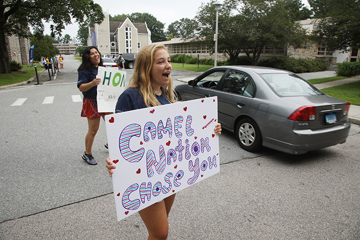 Students welcome cars arriving on campus.