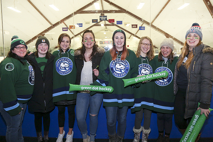 Fans, wearing green, pose together before the start of the Green Dot Hockey Game.