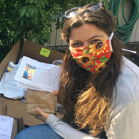 Ana Clarkson '21 with the packages of cloth masks she helped create as a team lead with Seamstresses Unite.