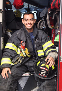 Hector Salazar ’20, a firefighter, dressed in his gear. 