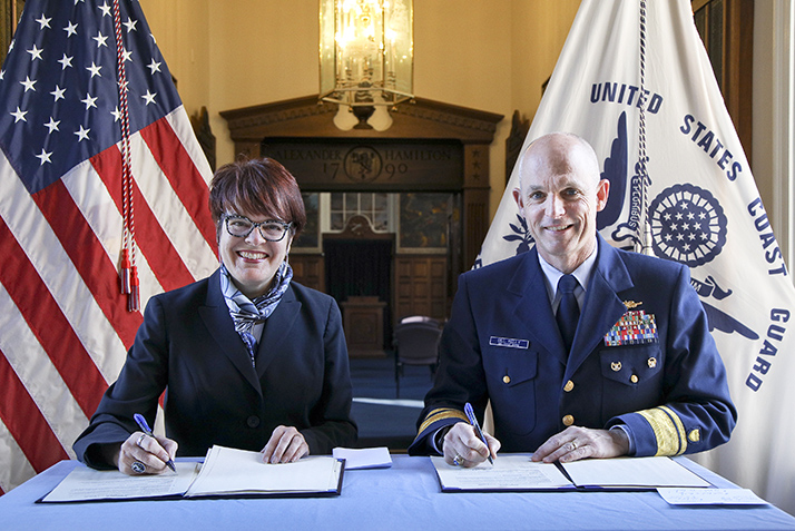 President Katherine Bergeron and the superintendent of the U.S. Coast Guard Academy, Rear Admiral William G. Kelly, sign the new MOA.