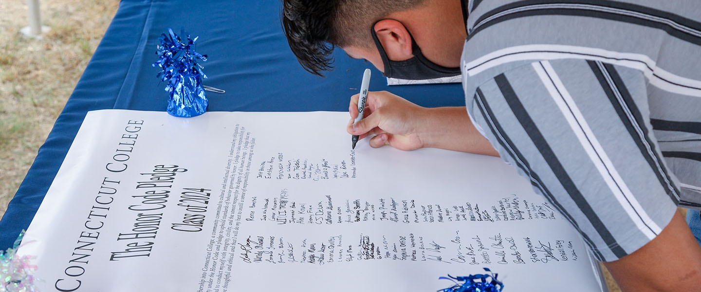 A student signs the Honor Code pledge
