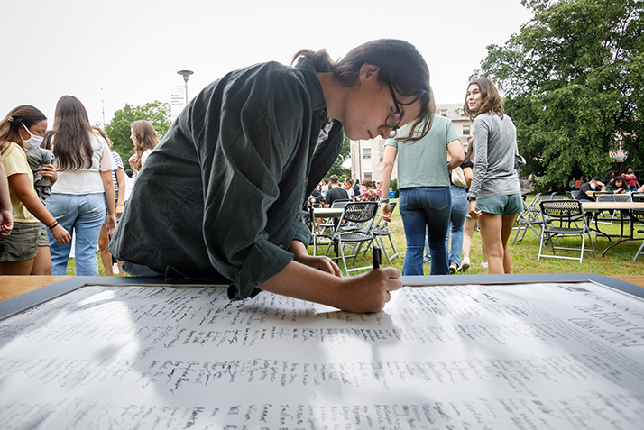 A student signs the Honor Code Pledge. 