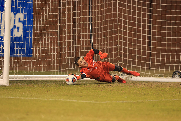 The goalie saves a penalty kick attempt. 