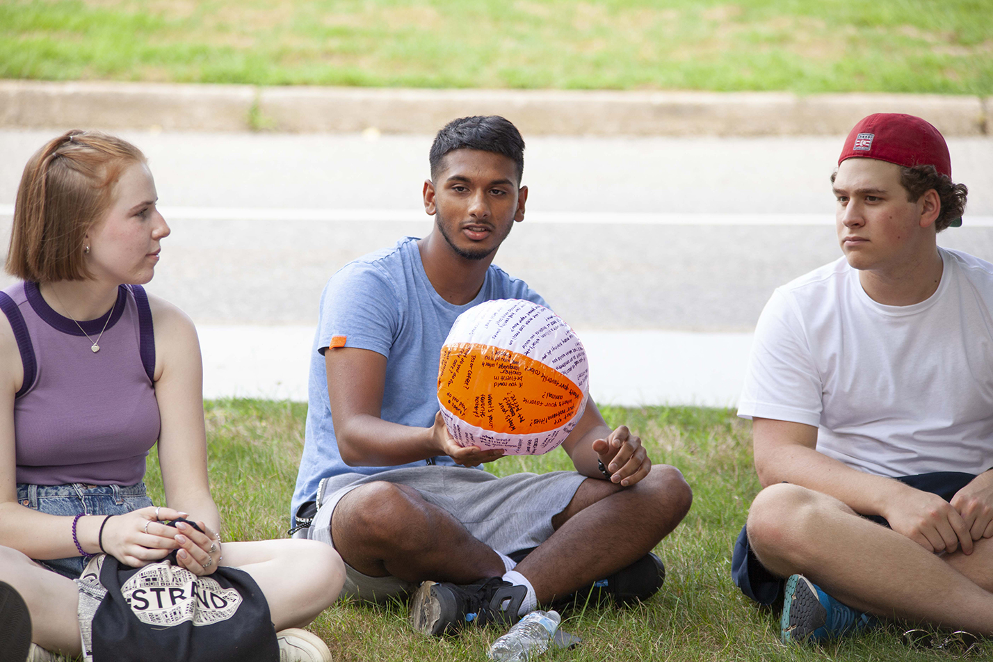 A student passes a beach ball during an ice-breaker activity.