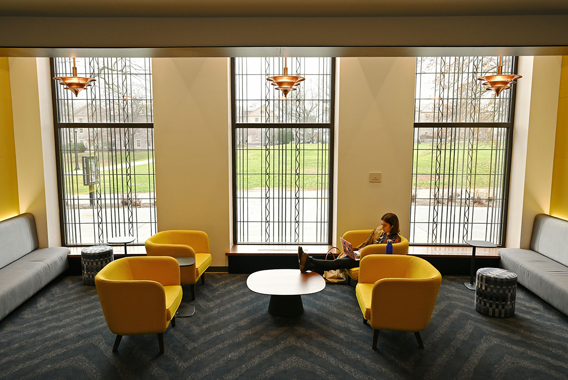 A student studies in the Athey Center lobby.