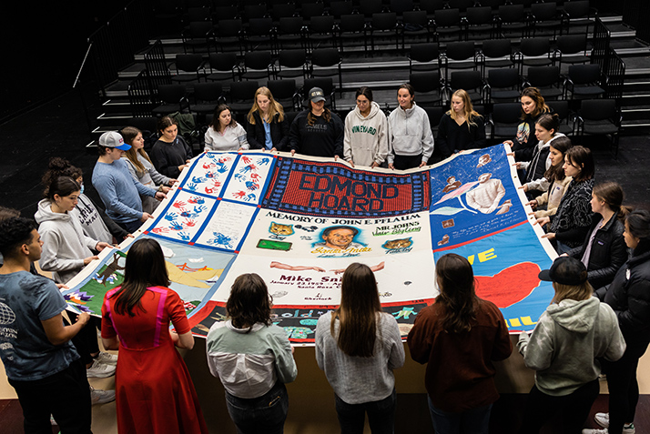 Students help unfold a portion of the AIDS quilt