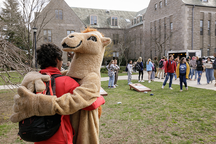 The Camel mascot gets a hug from a student.