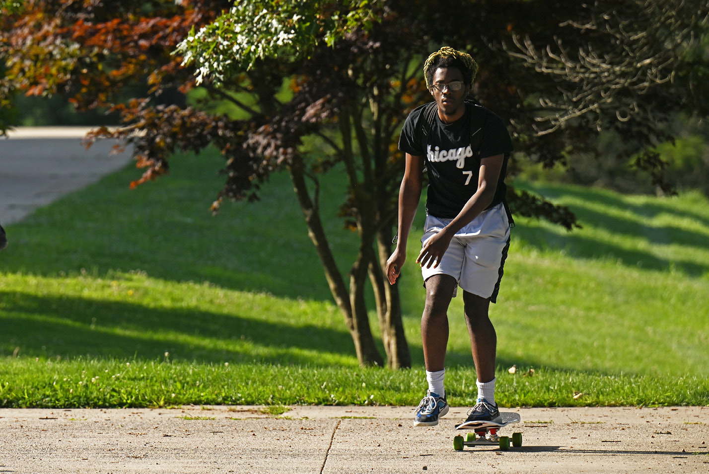 A student skateboards around Tempel Green.