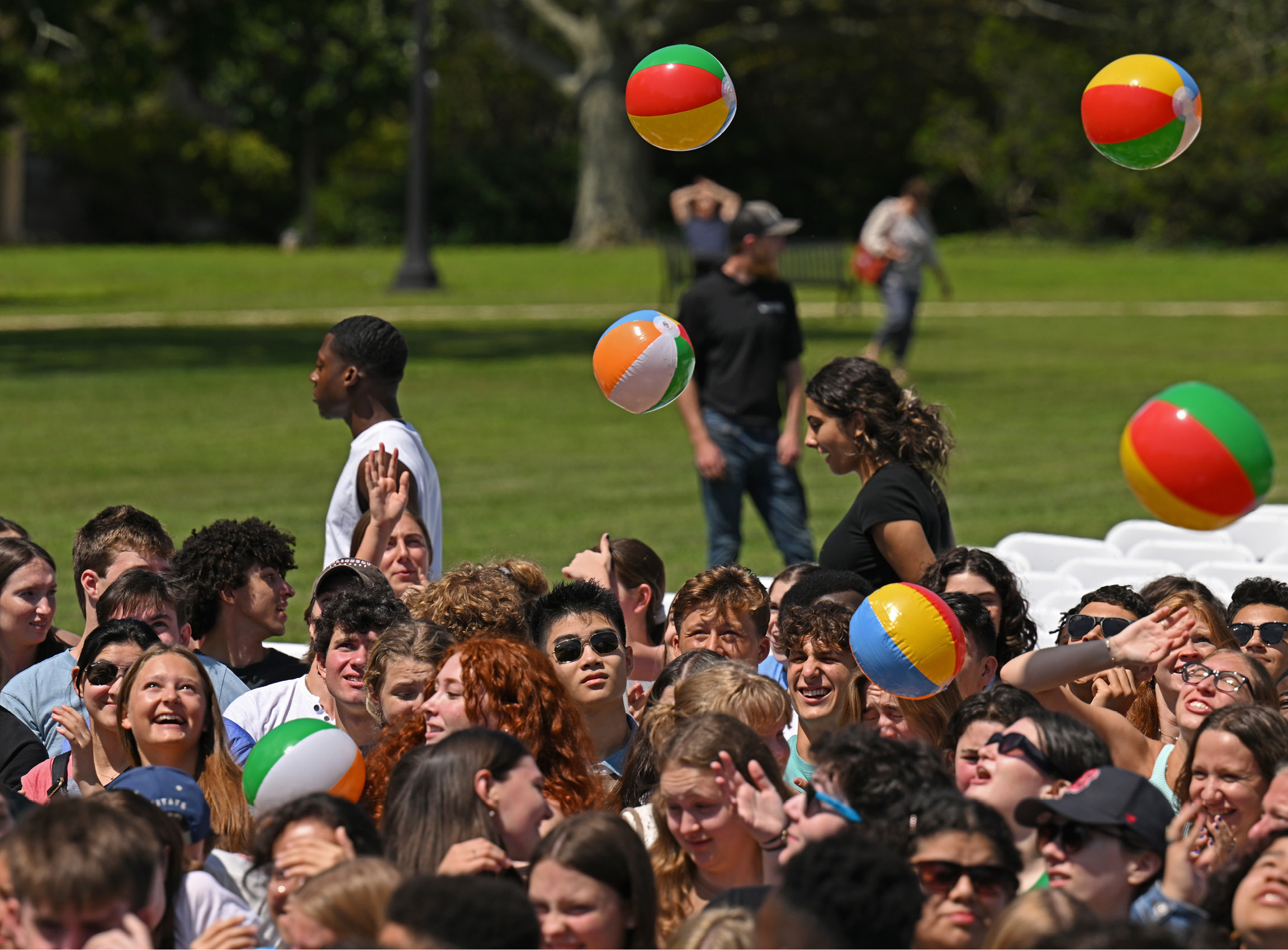 Beach balls fly over a crowd of students on the Green during Arrival Day.