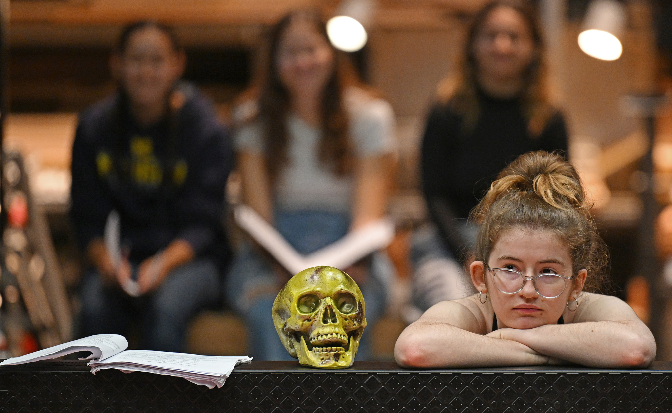 A theater student poses by a prop skull