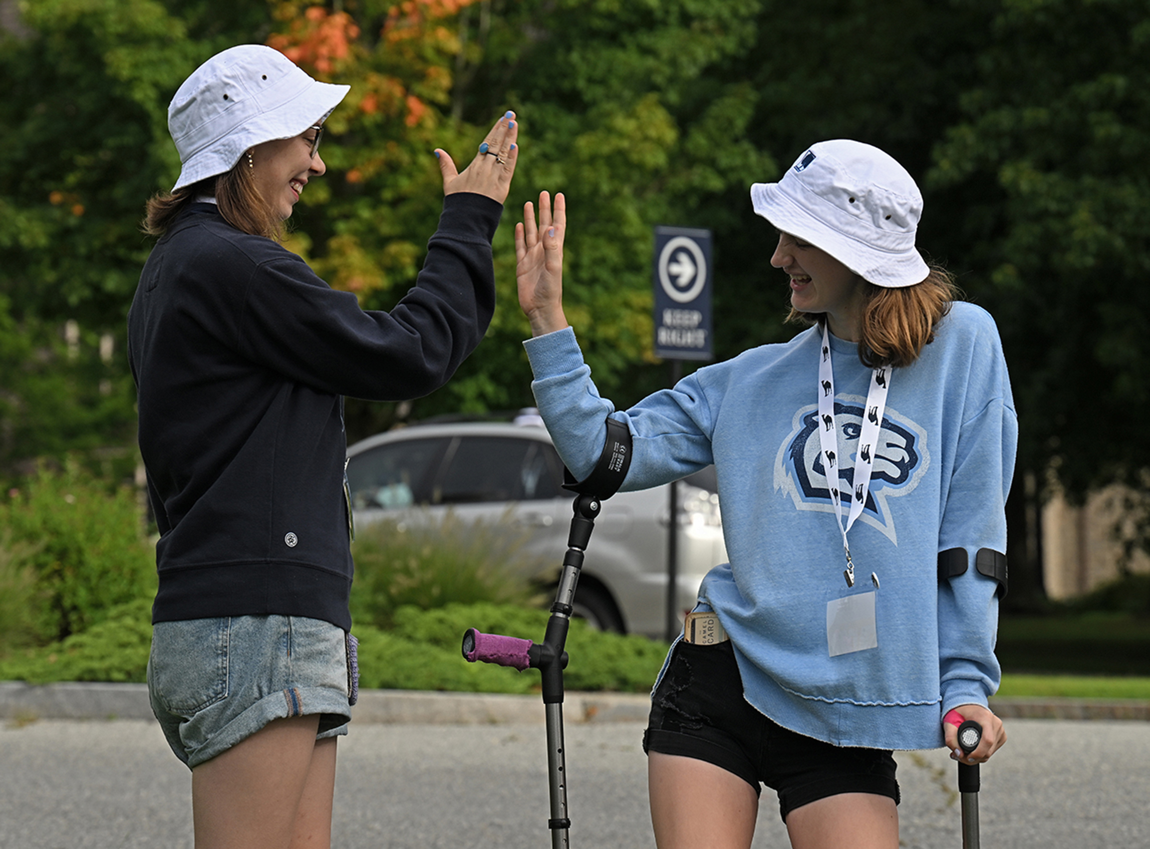 Two students high five each other.