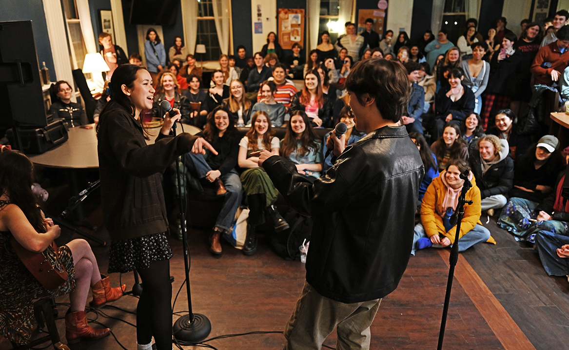 Two singers perform before a packed house.