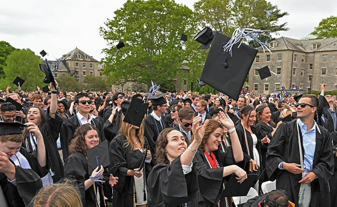 graduating students toss their mortarboard caps into the air at the end of commencement exercises