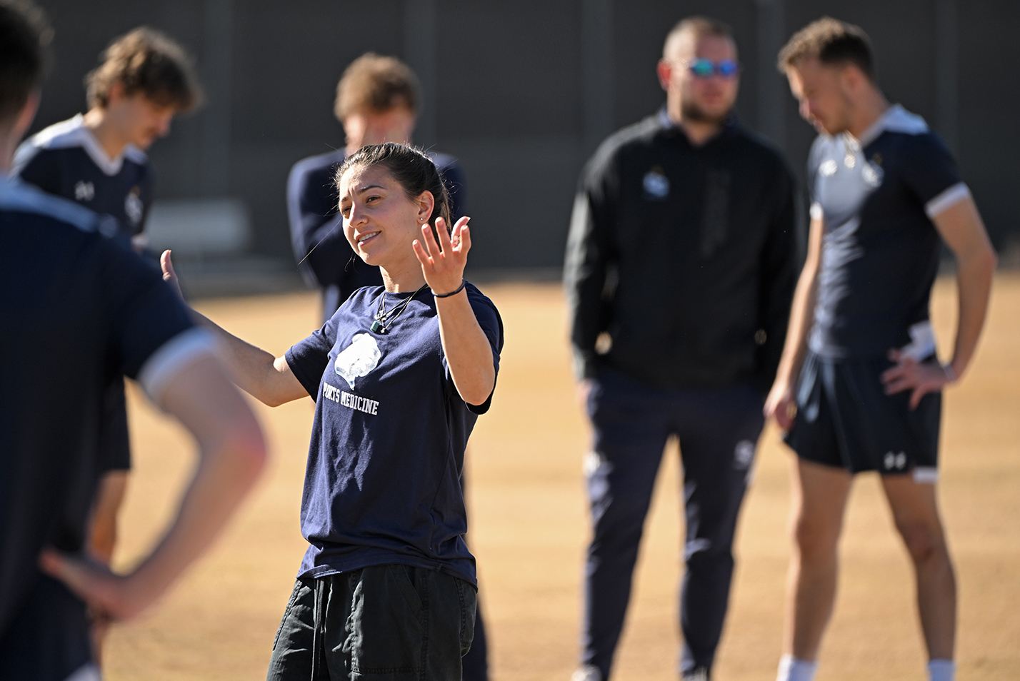 An athletic trainer leads the soccer team in flexibility exercises.