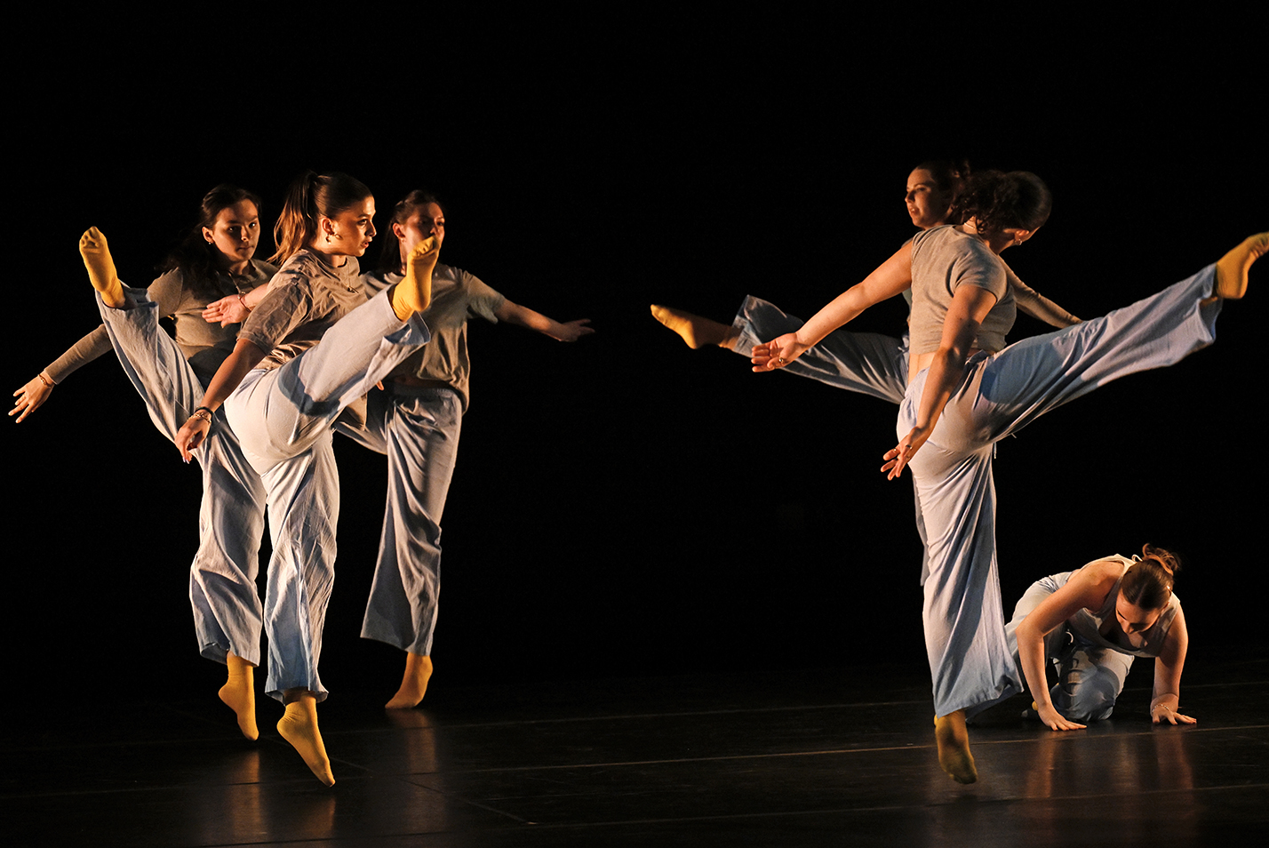a group of dancers perform high-kicking steps