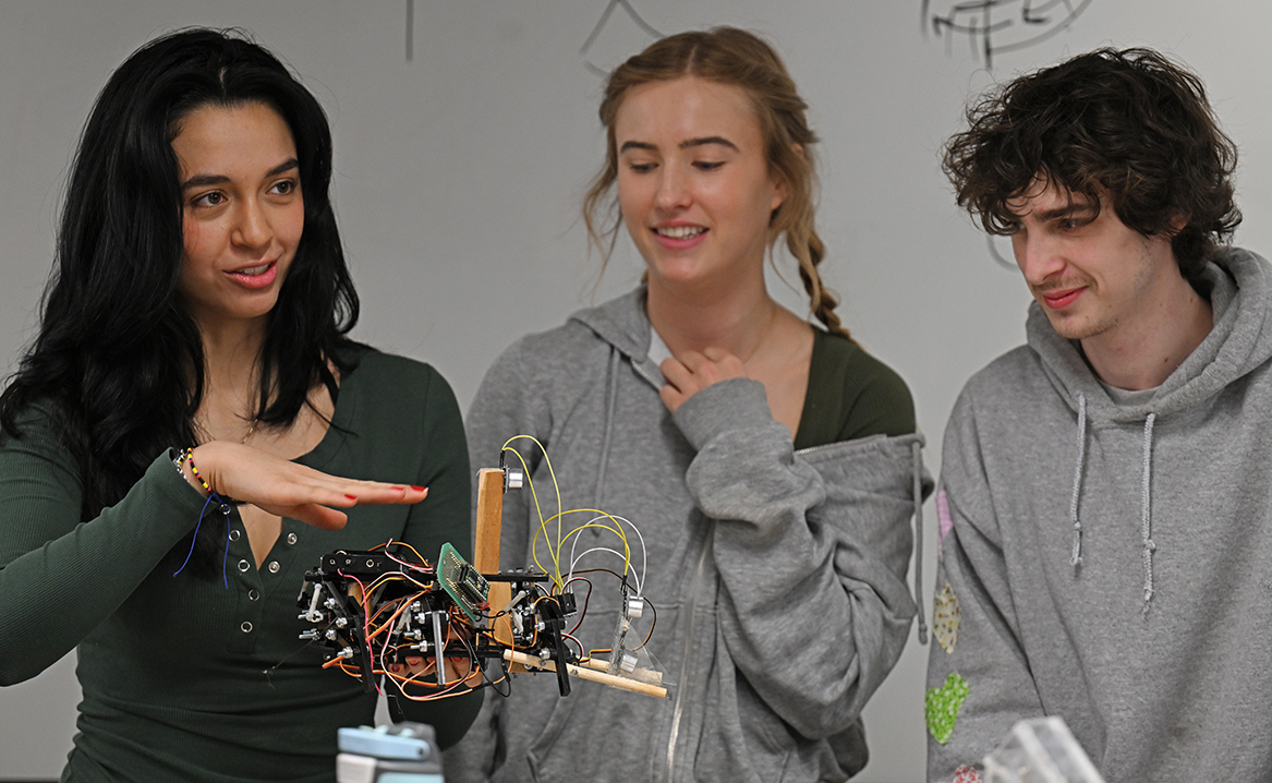three students explain a small robot creation.