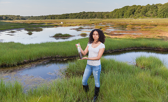 Student in a marsh doing summer research