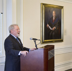 President Emeritus Norman Fainstein speaks in front of his official presidential portrait.